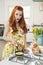 Portrait of a redheaded woman preparing omelet