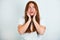 Portrait of redheaded young woman looking amazed standing on isolated white backgroung touching her face surprisingly, body