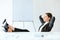 Portrait of relaxed business woman sitting with legs on desk