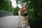 Portrait of relaxed fitness young woman on wooden bridge in park