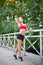 Portrait of relaxed fitness young woman on wooden bridge in park