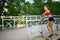 Portrait of relaxed fitness young woman on wooden bridge in park