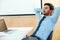 Portrait of a relaxed young businessman sitting in a bright office