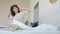 Portrait of relaxed young lady waking up in comfy bed smiling stretching arms and body