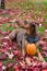 Portrait of rescue dog, Doberman mix, outside on lawn with red maple leaves, fall harvest pumpkin