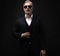 Portrait of a respectable mature man in a suit and sunglasses on a black background. Businessman portrait. Copy space