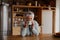 Portrait of retired biracial elderly female leaning on modern kitchen counter smiling at camera, taking sip of morning