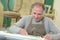 Portrait retired carpenter sitting at workshop