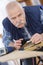 Portrait retired carpenter sitting at workshop