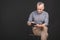 Portrait of retired senior man holding in his hand a digital tablet while sitting, holding glasses. Isolated against black