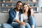 Portrait Of Romantic Multicultural Couple Relaxing On Couch At Home And Hugging