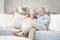 Portrait of romantic senior couple sitting on sofa in living room