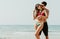 Portrait of romantic young beautiful couple in love embracing at the beach. Couple on travel honeymoon summer holidays romance.