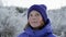 Portrait ruddy girl looking around in winter forest on walk. Close up face freckled teenager girl in knitted hat and