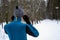 Portrait of a runner from the back wearing headphones and preparing to run in the winter forest