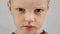 Portrait sad caucasian boy emotions anger, discontent, frustration, hatred. Portrait of fair-haired displeased child, an