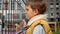 Portrait of sad little boy looking through metal fence. Child depression, problems with bullying, victim in school, emigration,