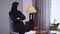 Portrait of sad Muslim woman in black clothes sitting at home alone. Upset beautiful woman in hijab looking out the