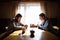 Portrait of sad poor mature couple praying at the table indoors at home, poverty concept.