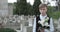 Portrait of sad teen boy turning head and looking to camera. Crop view of kid holding white lily flower while standing