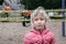 Portrait of sad upset Caucasian girl on closed playground outdoor. Kids play area locked with yellow caution tape in Toronto city