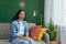 Portrait of sad woman alone at home, pensive Hispanic woman sitting on sofa in living room