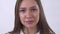 Portrait of sad young woman crying close up on white background in studio. Tear runs down cheek