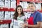 Portrait Of Salesman Assisting Customer In Buying Pet Food