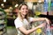 Portrait of saleswoman, woman smiling and looking at camera in supermarket. Pleasant friendly female seller standing in the store