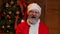 Portrait of Santa Claus looking at the camera waves hello and makes gesture come here. Old man in red suit and hat