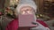 Portrait Santa Claus opens gift magic box and looks into it, from box shines magical bright light on Santa`s face. New