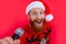 Portrait of Santa Claus singing Christmas songs isolated on red. Enjoying Christmas karaoke party