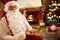 Portrait Santa Claus sitting and enjoying in cookies and milk