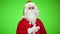 Portrait of santa claus stroking his beard in front of green background