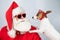 Portrait of santa claus in sunglasses and dog jack russell terrier in rudolf reindeer ears on a white background.