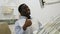 Portrait of satisfied african american man sitting in chair at dental office, showing thumbs up approval gesture after