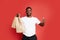 Portrait of satisfied courier male with delivery food in paper bags