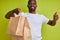 Portrait of satisfied courier male with delivery food in paper bags