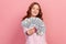 Portrait of satisfied curly haired young female lottery winner showing bunch of dollar banknotes at camera, profit and finance