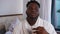 Portrait of satisfied handsome African American young man drinking morning coffee smiling looking at camera. Confident