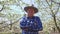 portrait satisfied senior farmer with hat puts his hands crossed