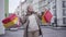 Portrait of satisfied senior female shopaholic spinning and dancing on city street with shopping bags. Mature Caucasian