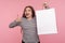 Portrait of satisfied shopper, excited woman in striped sweatshirt pointing shopping bag and looking surprised