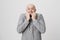 Portrait of scared adult man with opened mouth, holding hands near face over white background. Emotions and body