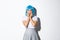 Portrait of scared asian woman gasping afraid, stare at camera ambushed, wearing blue party wig and schoolgirl uniform