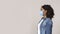 Portrait of scared black woman in medical mask over light background