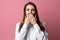 Portrait of scared brunette girl hold hands near mouth trembling fear, standing in stupor over pink background