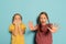 Portrait of scared little girls, sisters or siblings wearing casual style clothes isolated on blue background. Concept