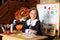 Portrait of a school girl on lesson in classroom. Back to school. A cute hardworking child is sitting at table in school.