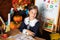 Portrait of a school girl on lesson in classroom. Back to school. A cute hardworking child is sitting at table in school.